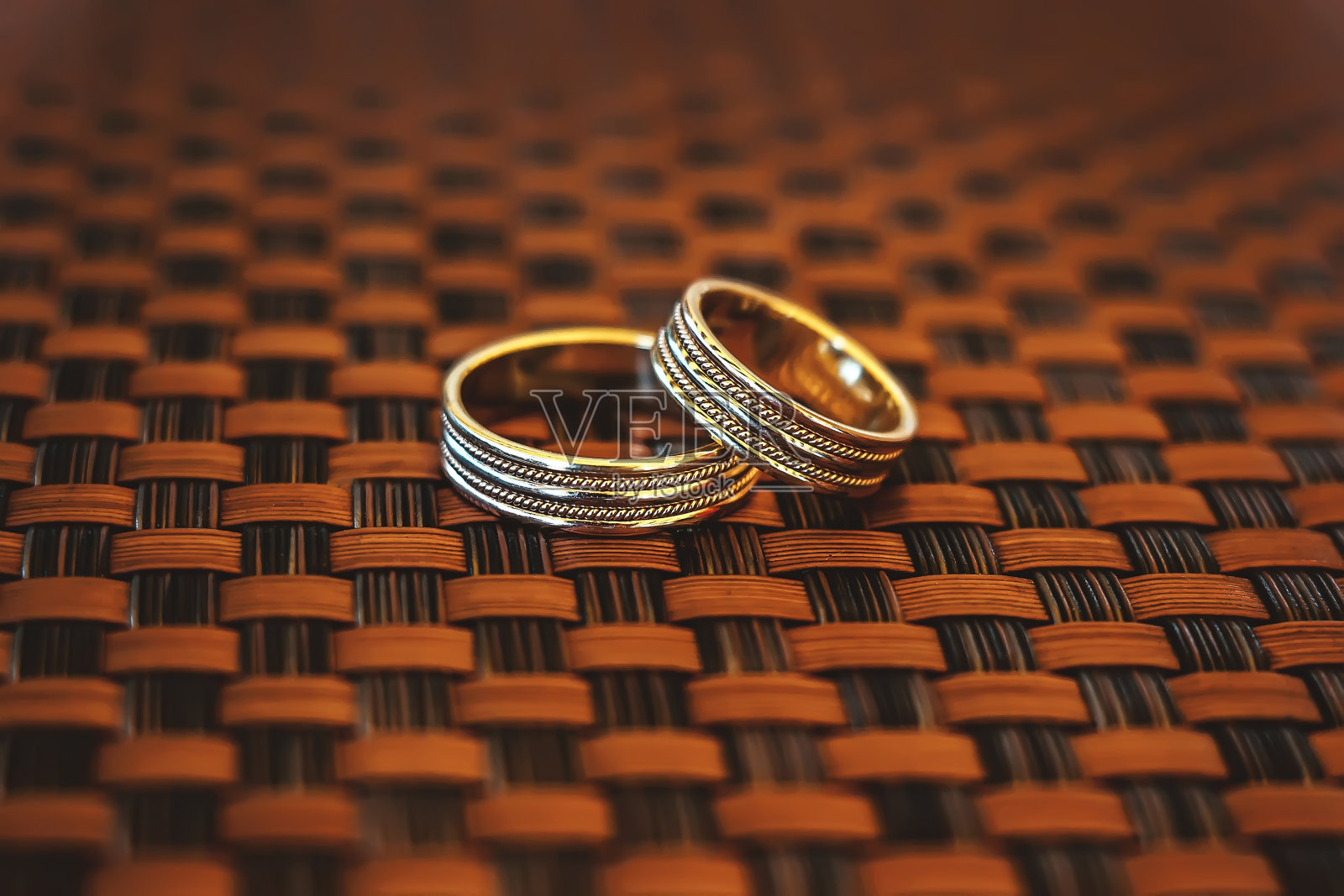 柳条背景上的两个金戒指照片摄影图片