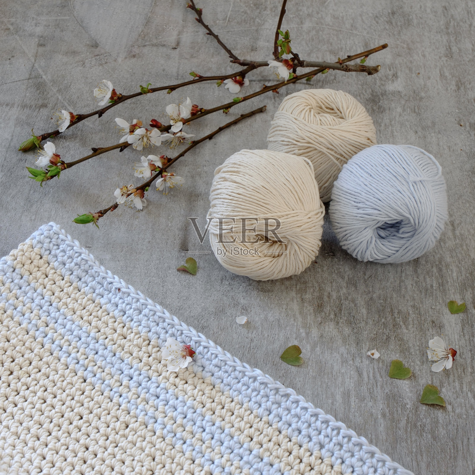 用钩钩的奶油色和蓝色纱线做成的球照片摄影图片