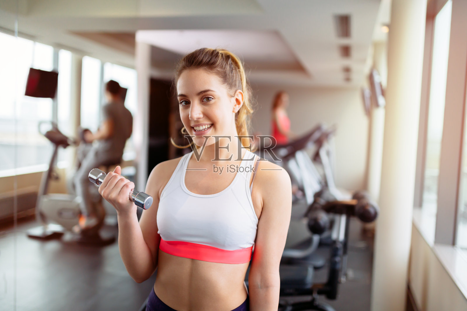 在健身房举重的漂亮女人照片摄影图片