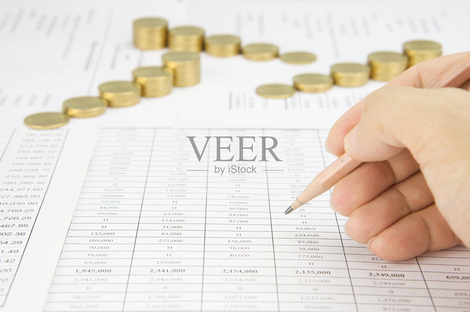 男人拿着铅笔审核有模糊步金币照片摄影图片