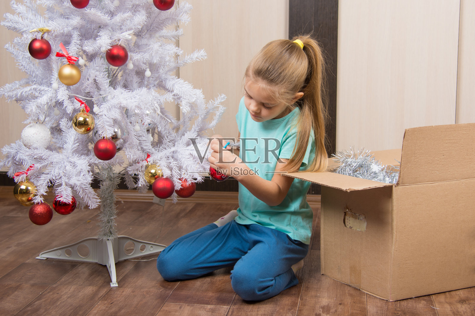 女孩在圣诞树旁玩球照片摄影图片