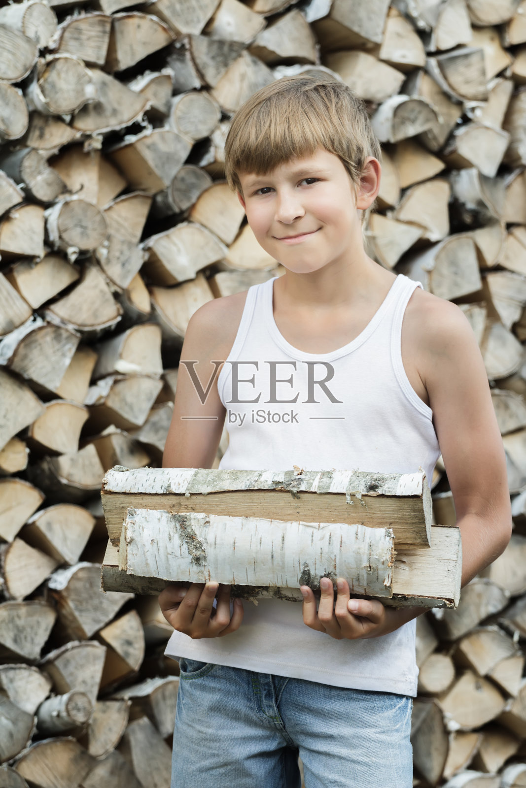 十几岁的樵夫在柴火旁的肖像照片摄影图片