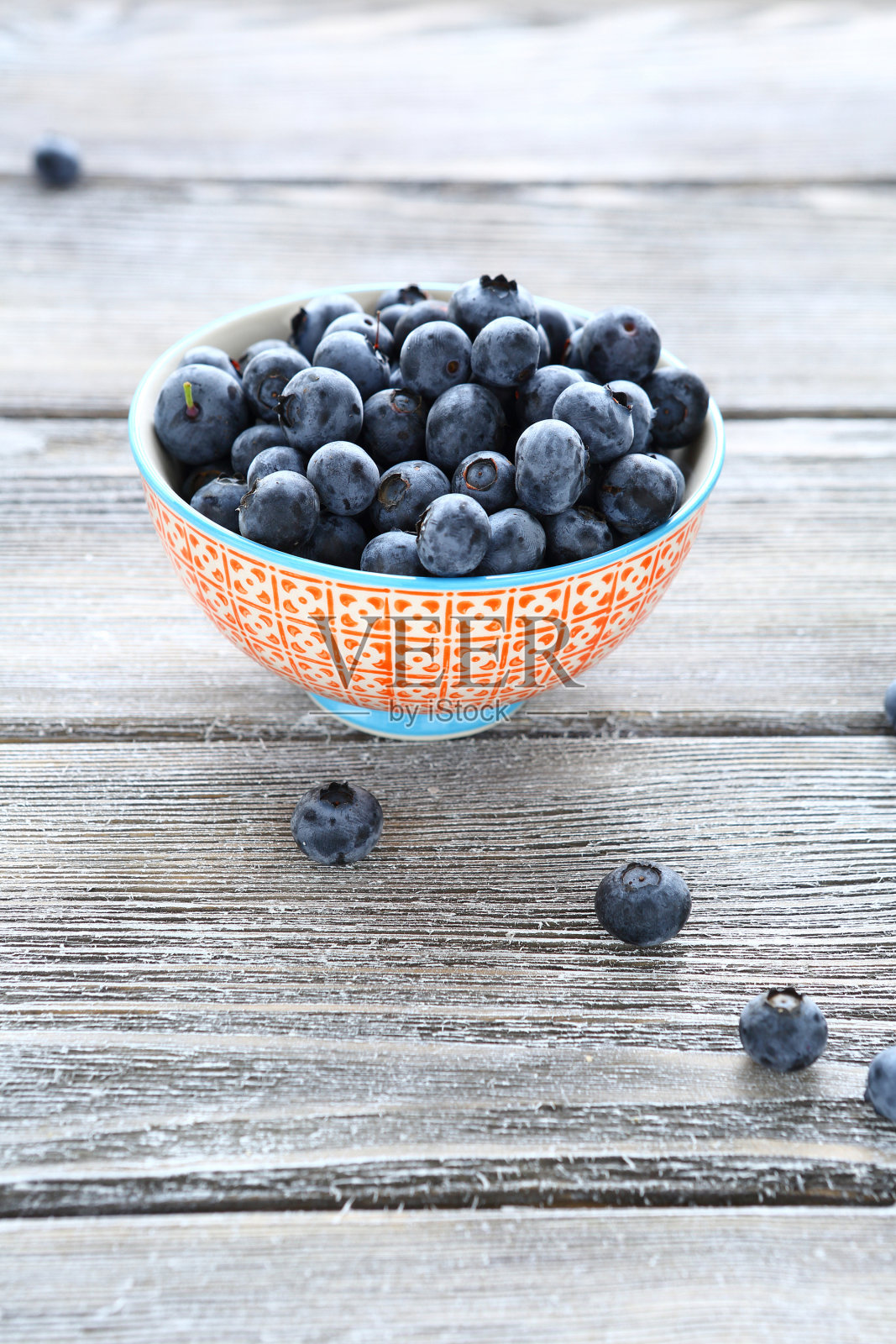 成熟的蓝莓放在桌子上的碗里照片摄影图片