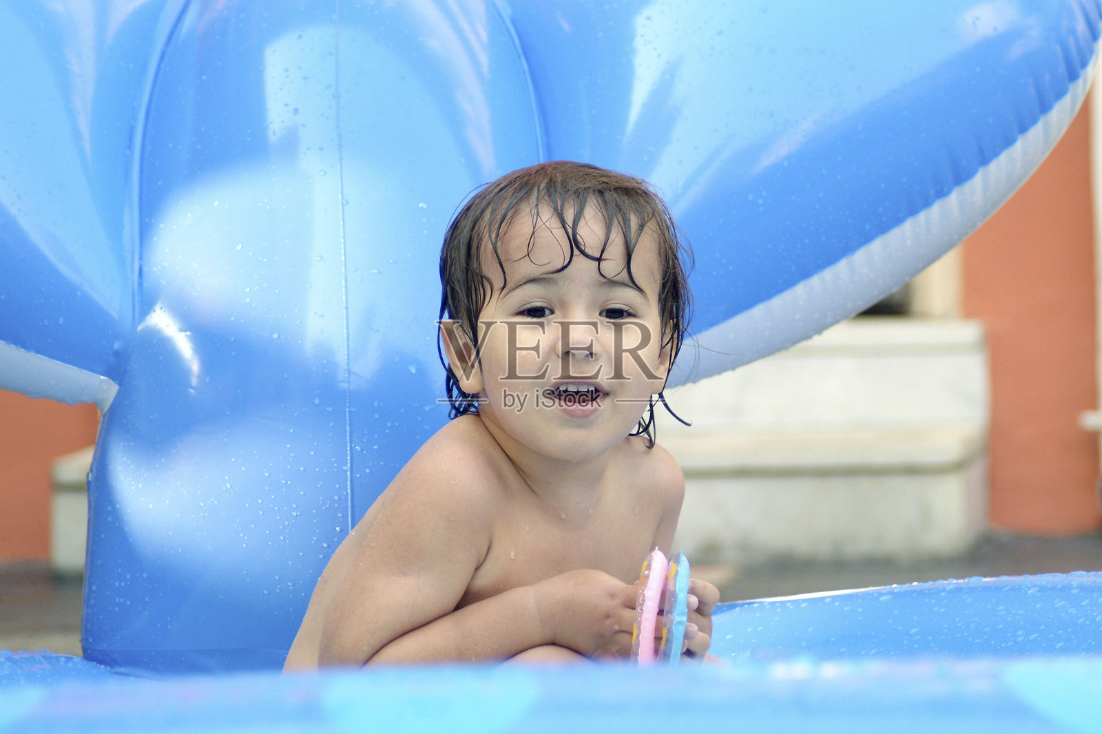 在充气游泳池里游泳的孩子。照片摄影图片