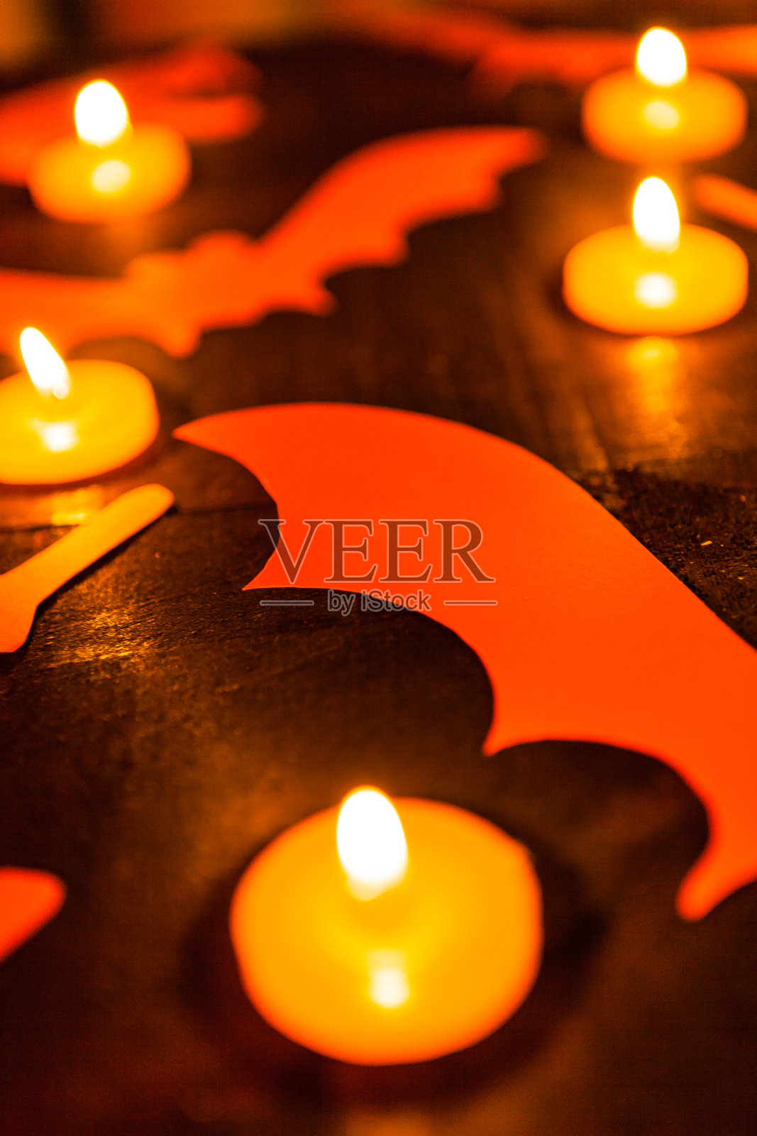 橙色蝙蝠和点燃的万圣节蜡烛照片摄影图片