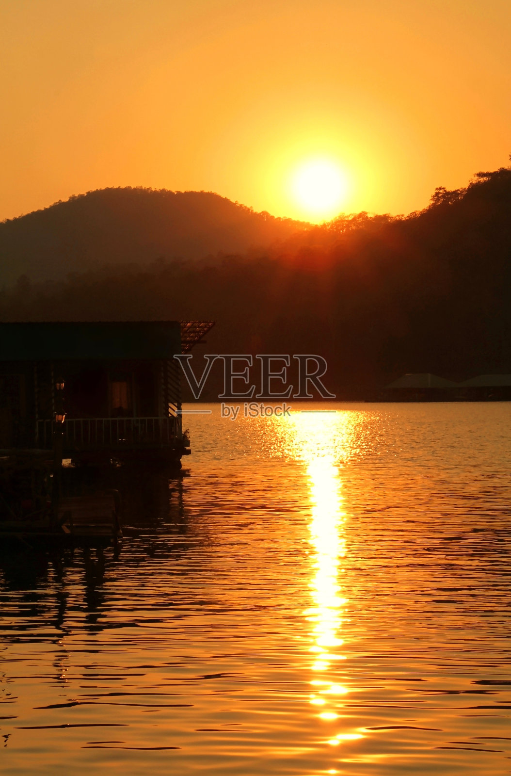 金色夕阳下漂浮的木屋的剪影照片摄影图片