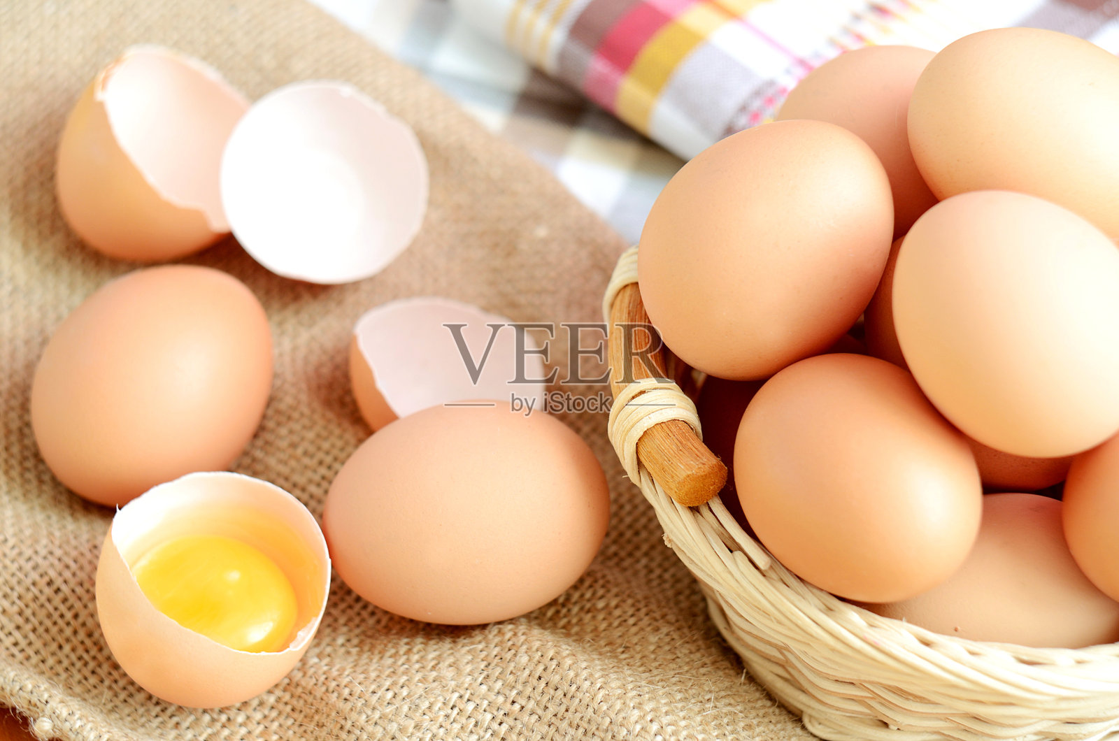 亚麻桌布上放有鸡蛋和生鸡蛋的篮子照片摄影图片