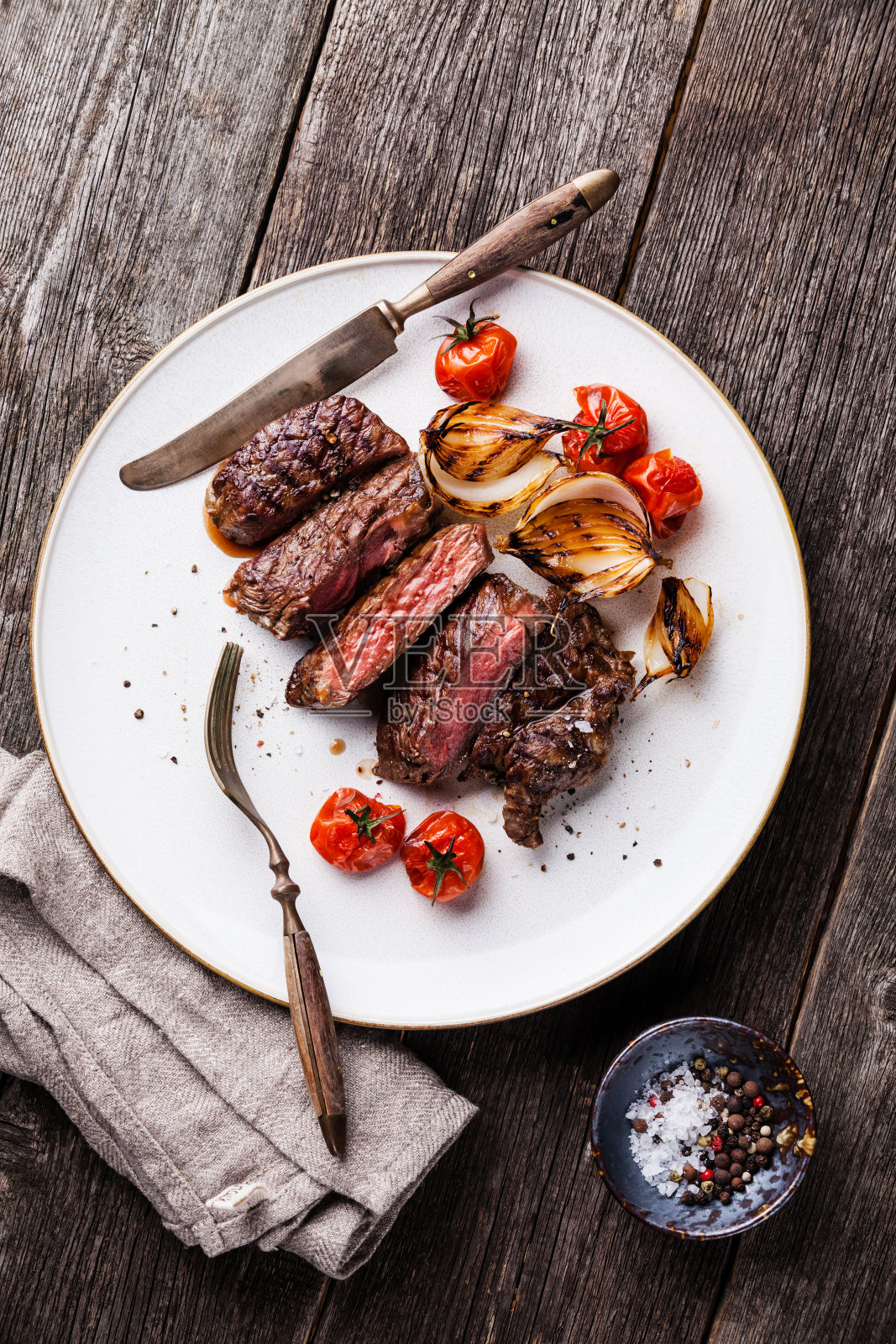 肋眼牛排配洋葱和番茄照片摄影图片