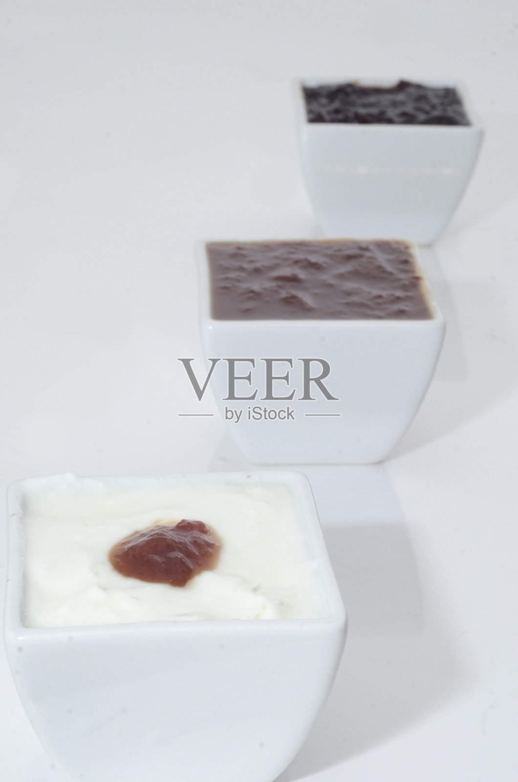 白碗里装着不同种类的果酱照片摄影图片