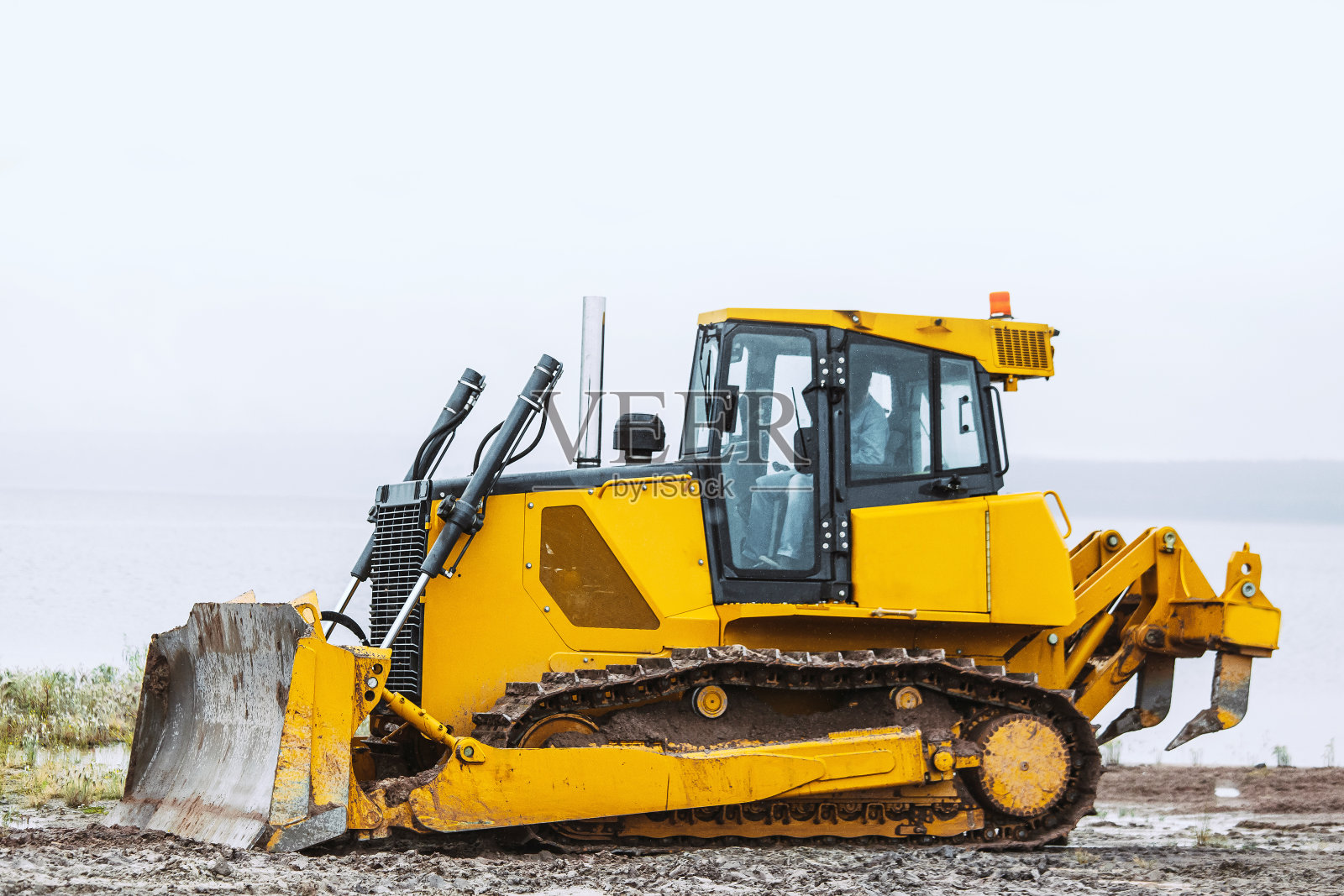 肮脏的黄色推土机在地面上向左行驶照片摄影图片