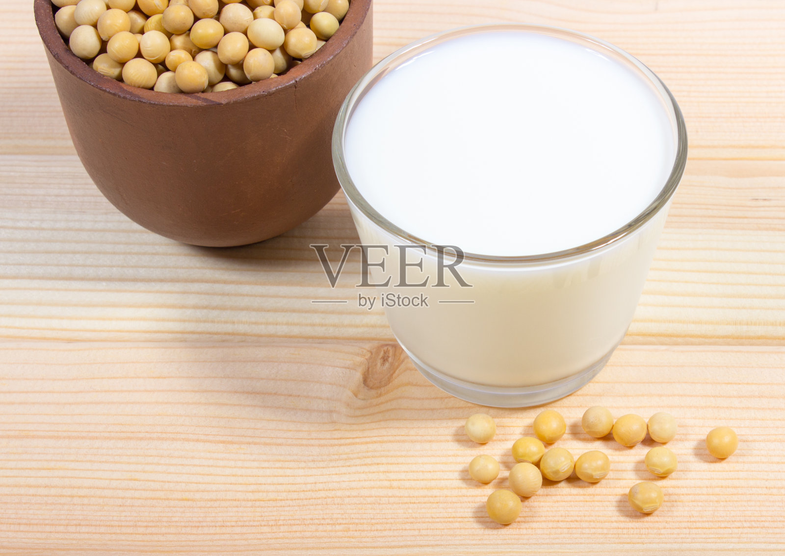 木制背景上的豆奶杯。照片摄影图片