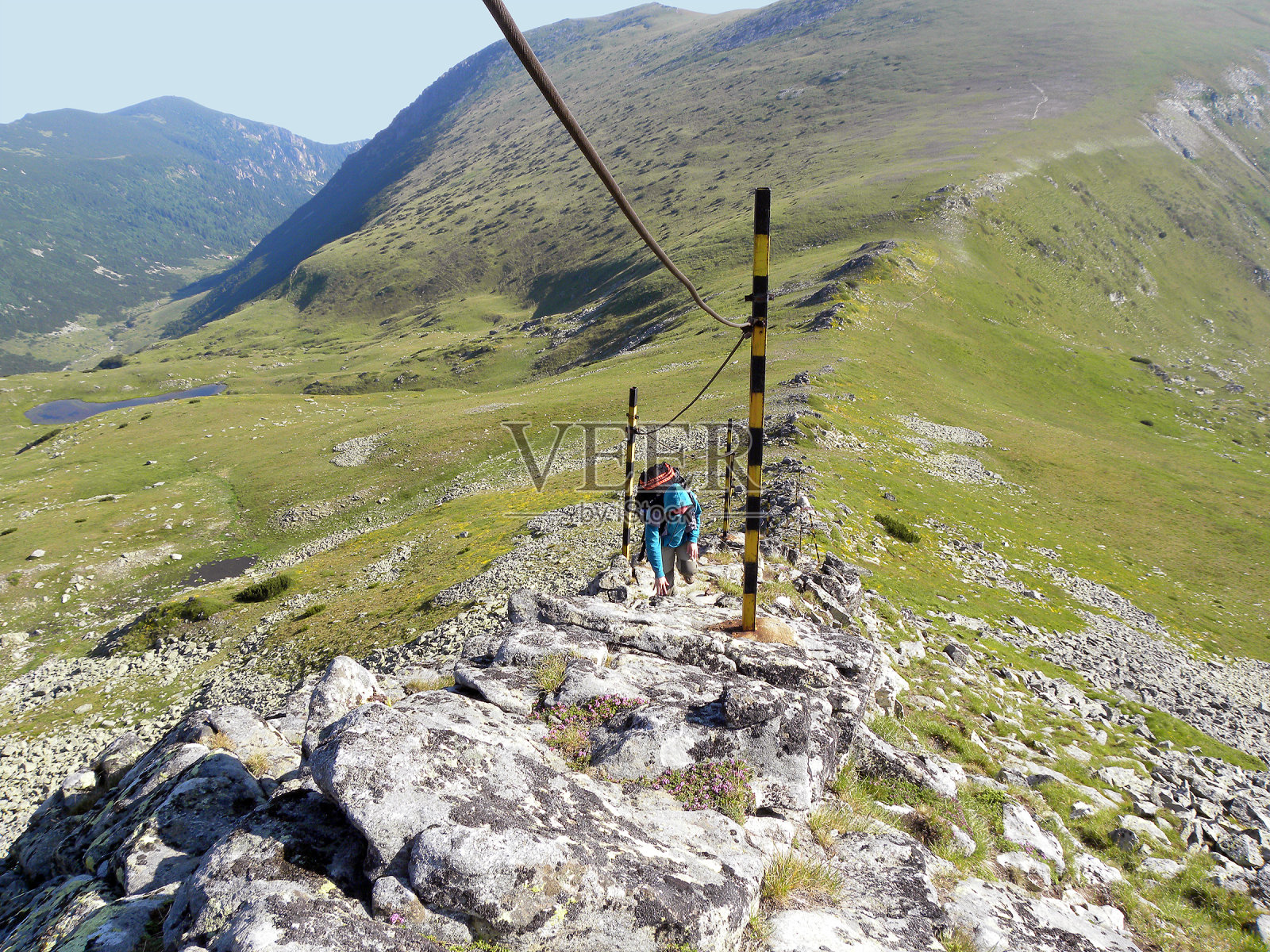 年轻的女孩在危险的山坡上用绳子攀爬照片摄影图片