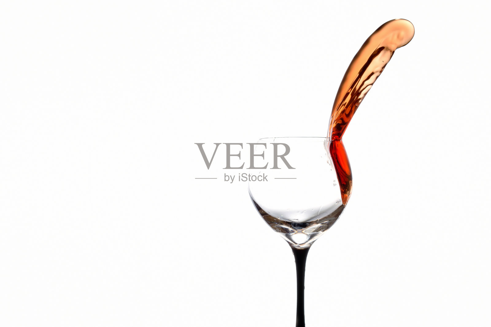 将葡萄酒倒入隔离的玻璃杯中照片摄影图片