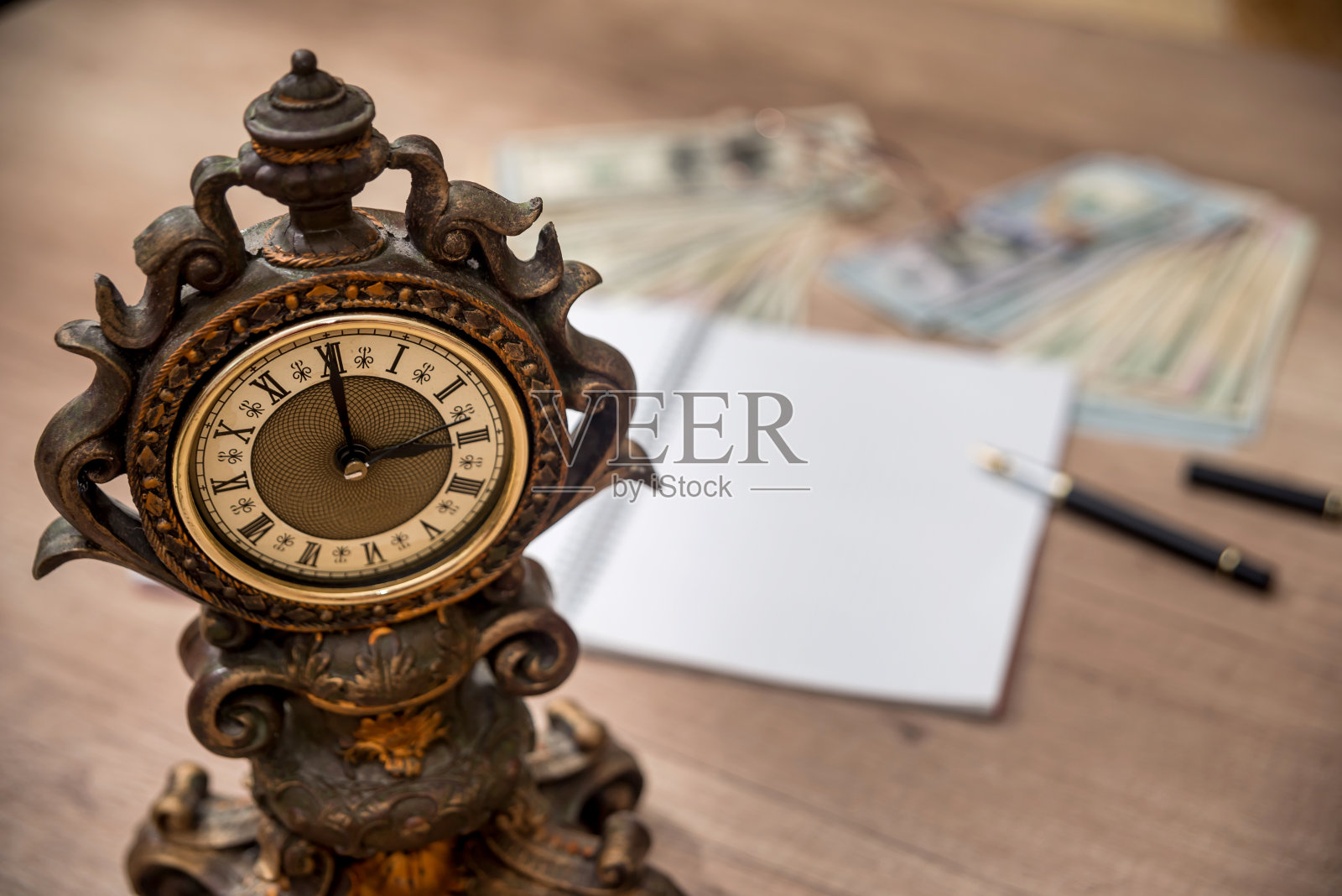 带着空记事本的旧钟。钱和笔照片摄影图片