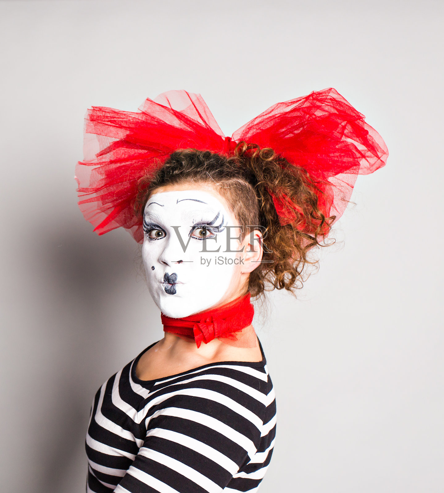 女小丑在工作室摆姿势，愚人节的概念照片摄影图片