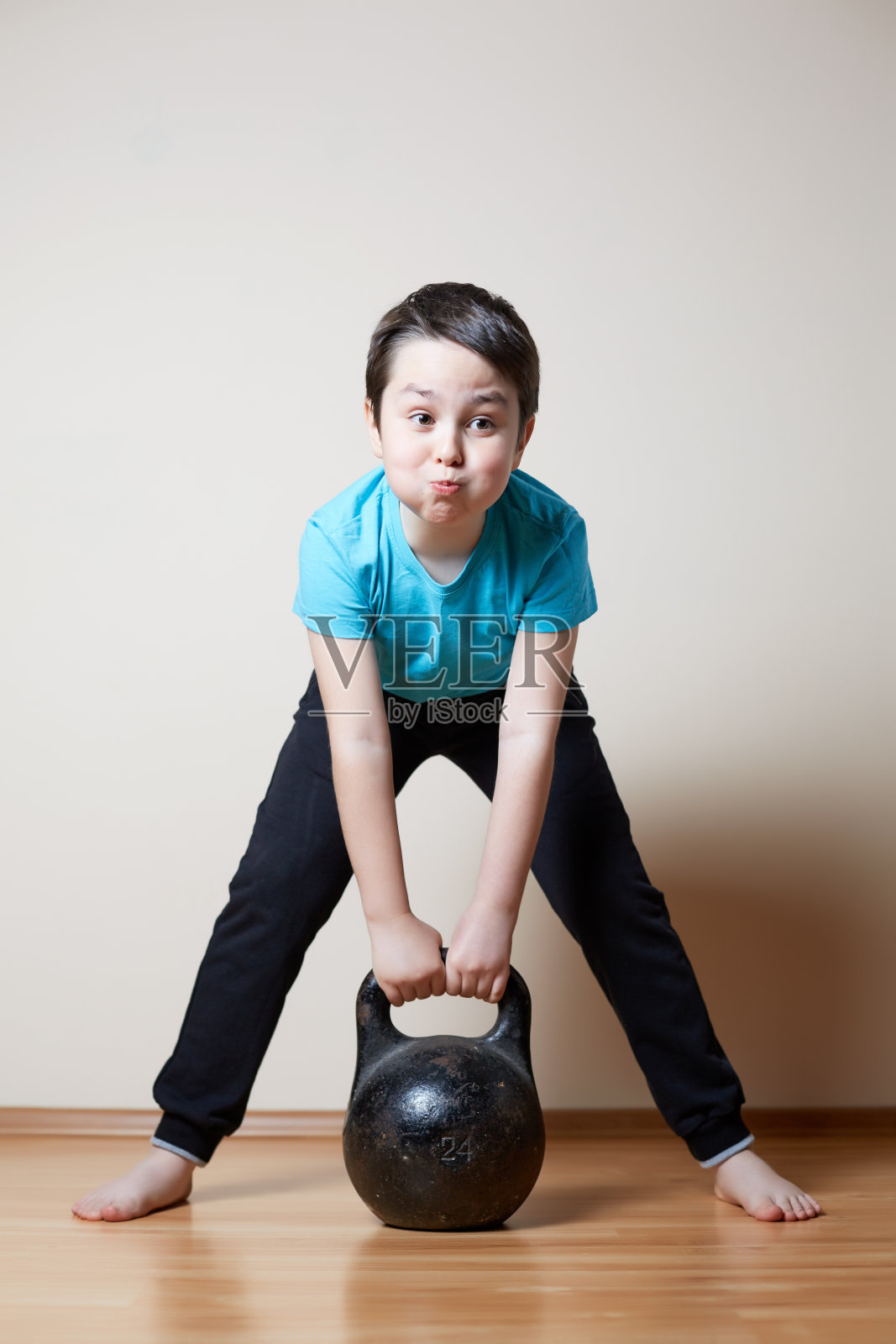 可爱的男孩举着哑铃照片摄影图片