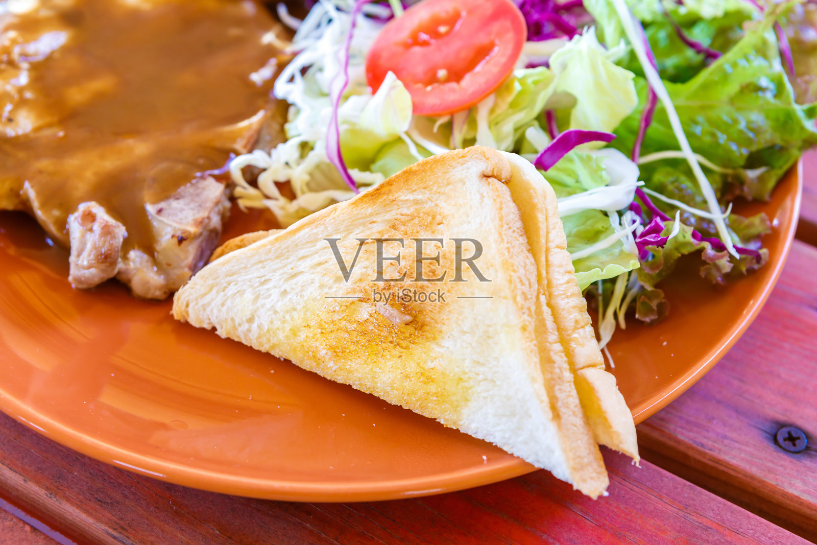 烤猪肉牛排配沙拉和面包照片摄影图片