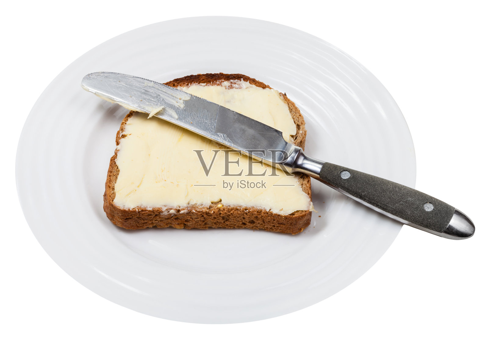 白盘子上放着黄油面包和餐刀照片摄影图片