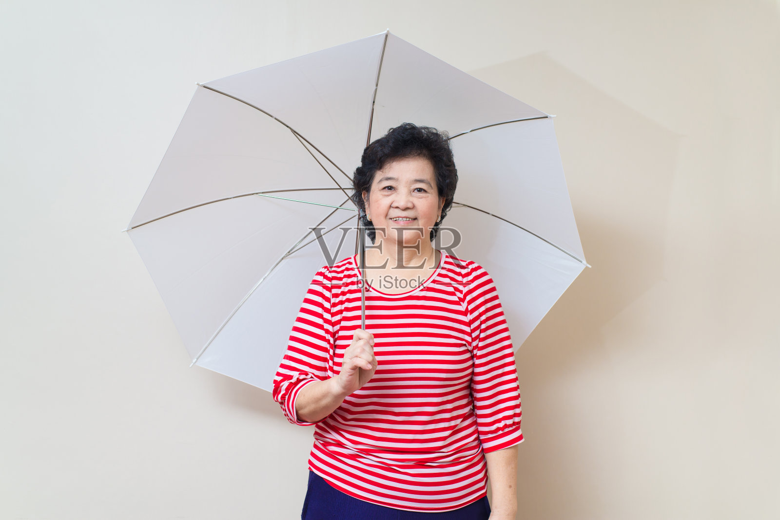 亚洲女人撑着伞在摄影棚拍摄，特有的色调照片摄影图片