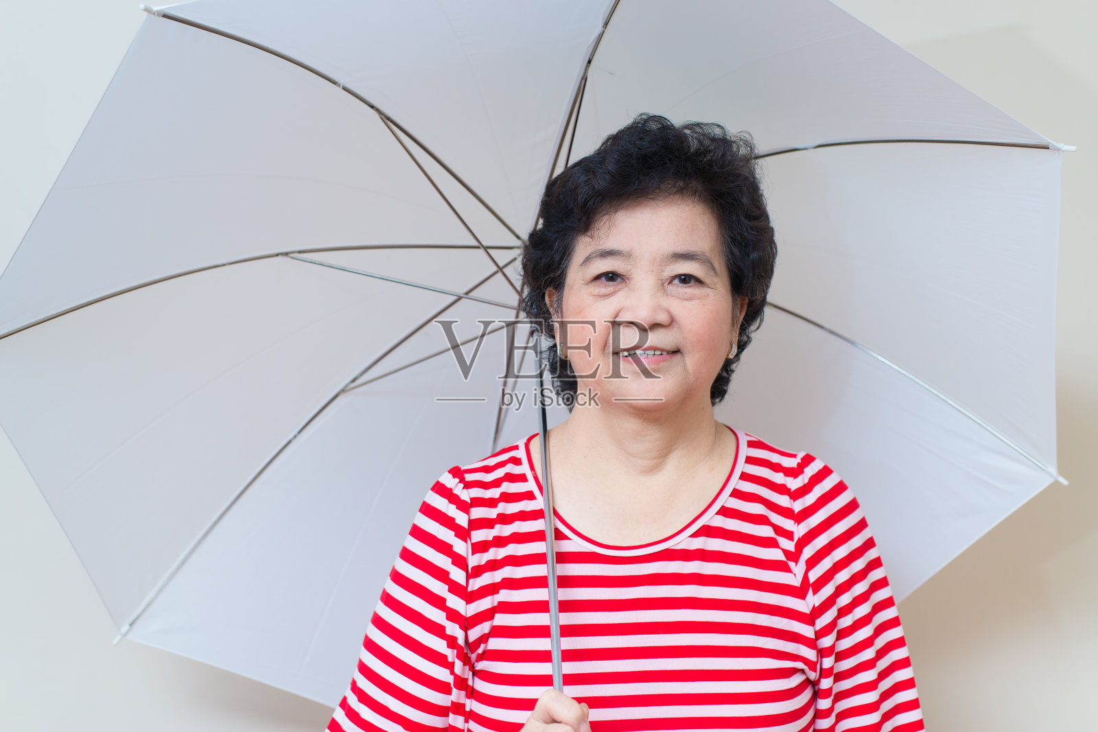 亚洲女人撑着伞在摄影棚拍摄，特有的色调照片摄影图片