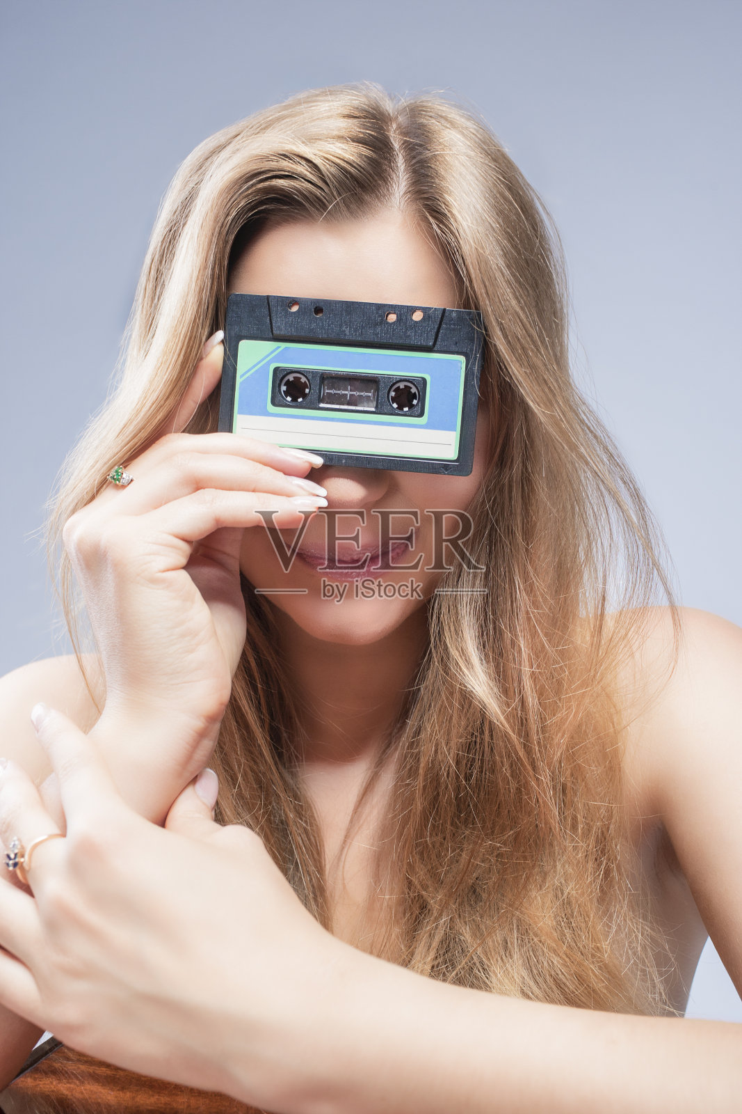 年轻的金发白种人拿着磁带在前面照片摄影图片