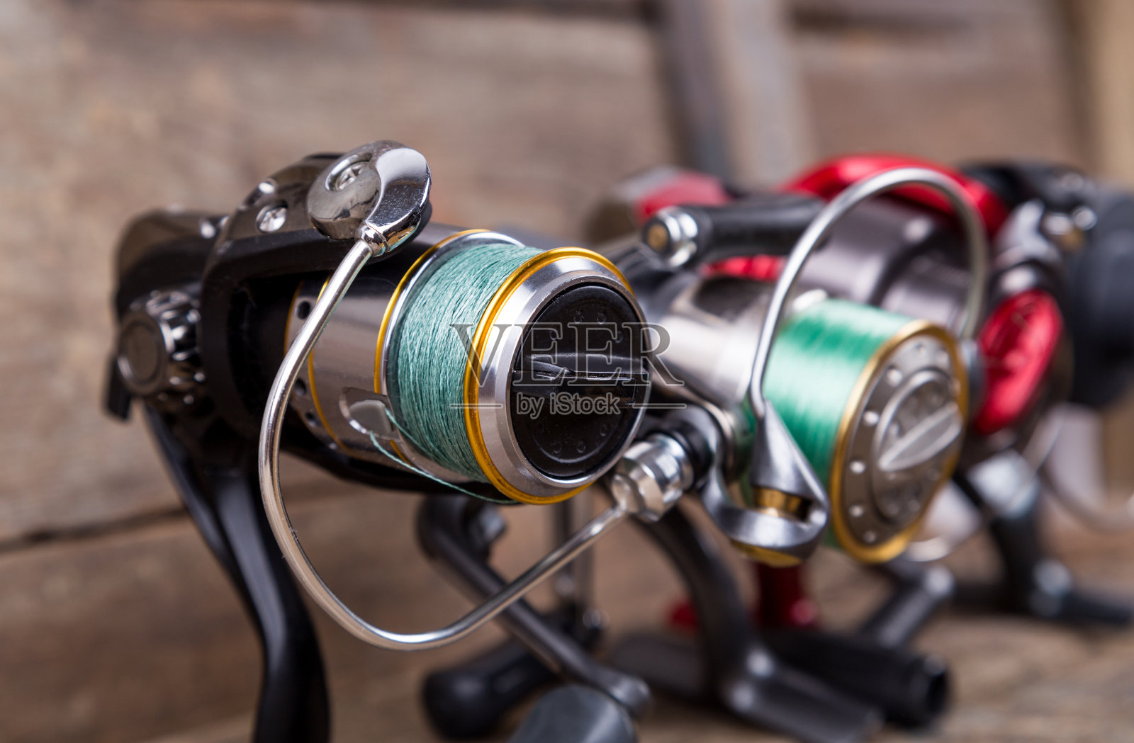 不同的钓鱼卷筒，以木纹为背景照片摄影图片