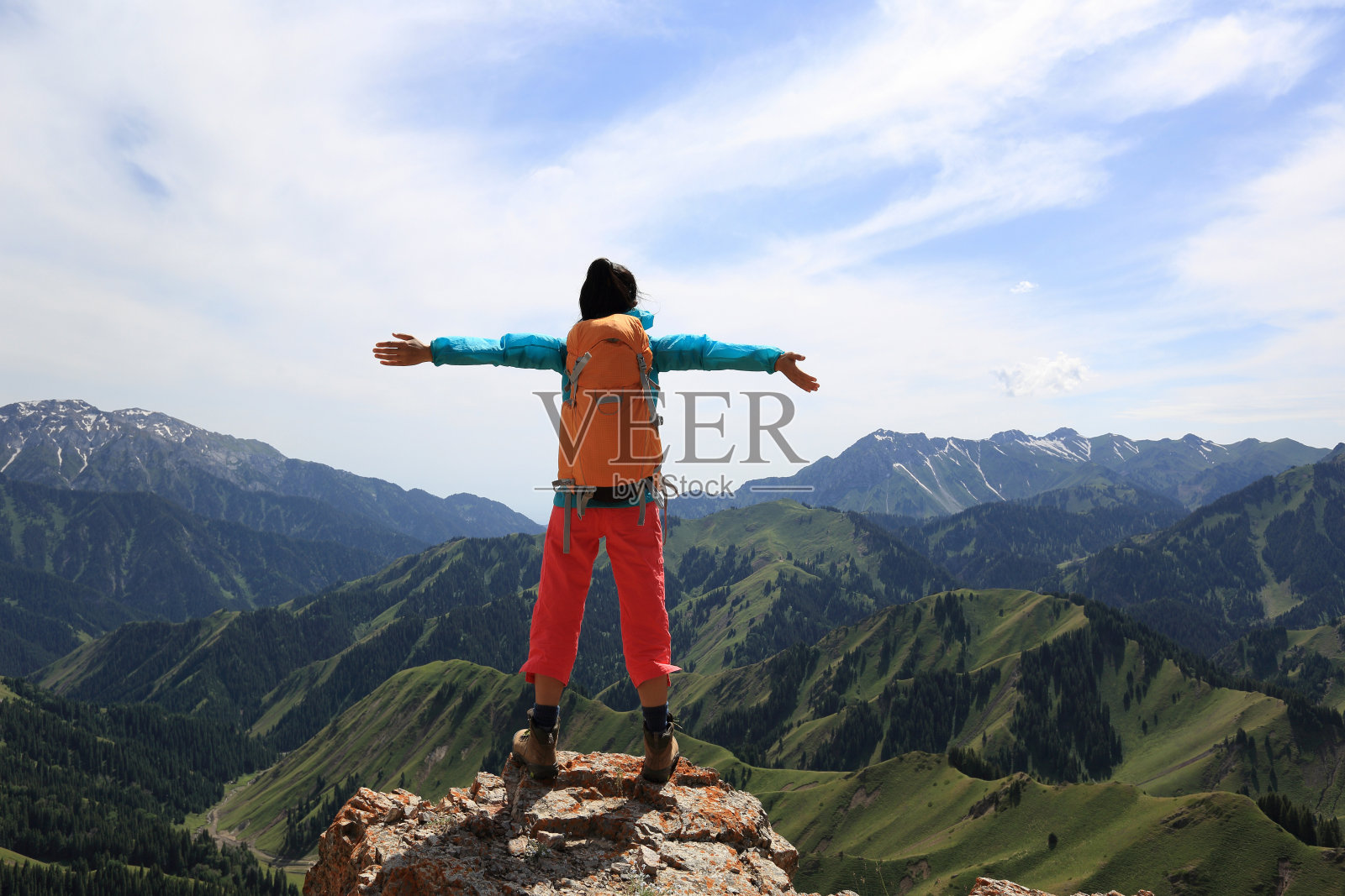 欢呼的年轻女子背包客在山顶悬崖张开双臂照片摄影图片