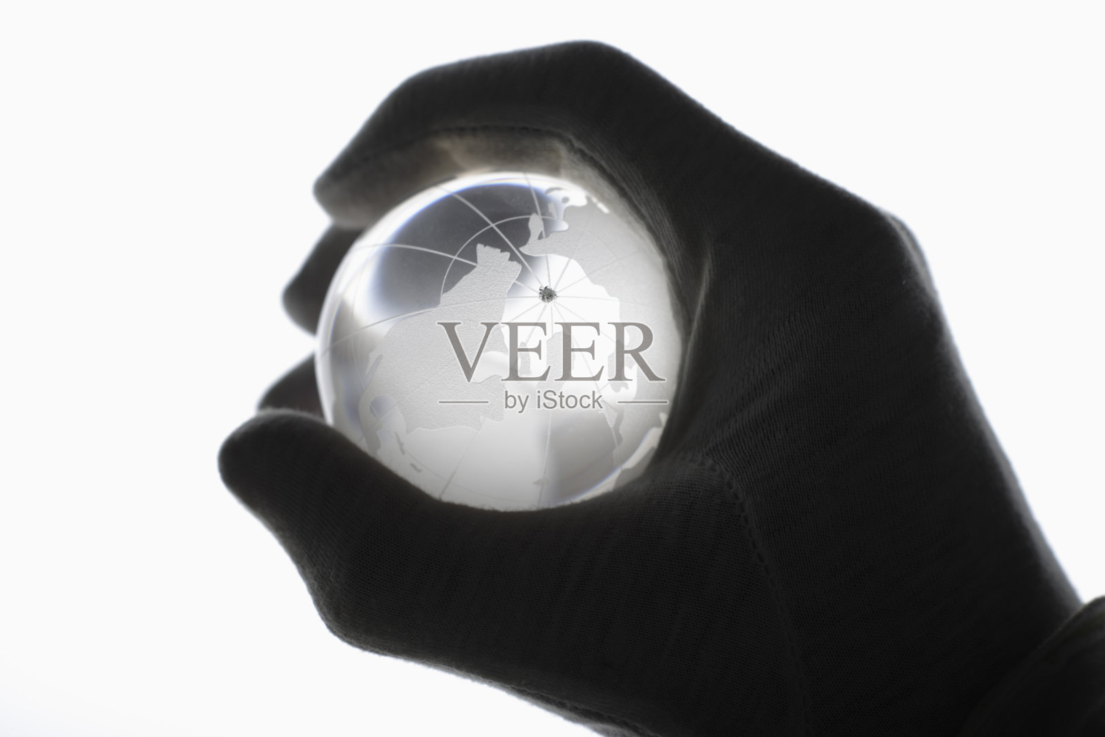 戴着棉手套的人的手抓着白色的玻璃球照片摄影图片