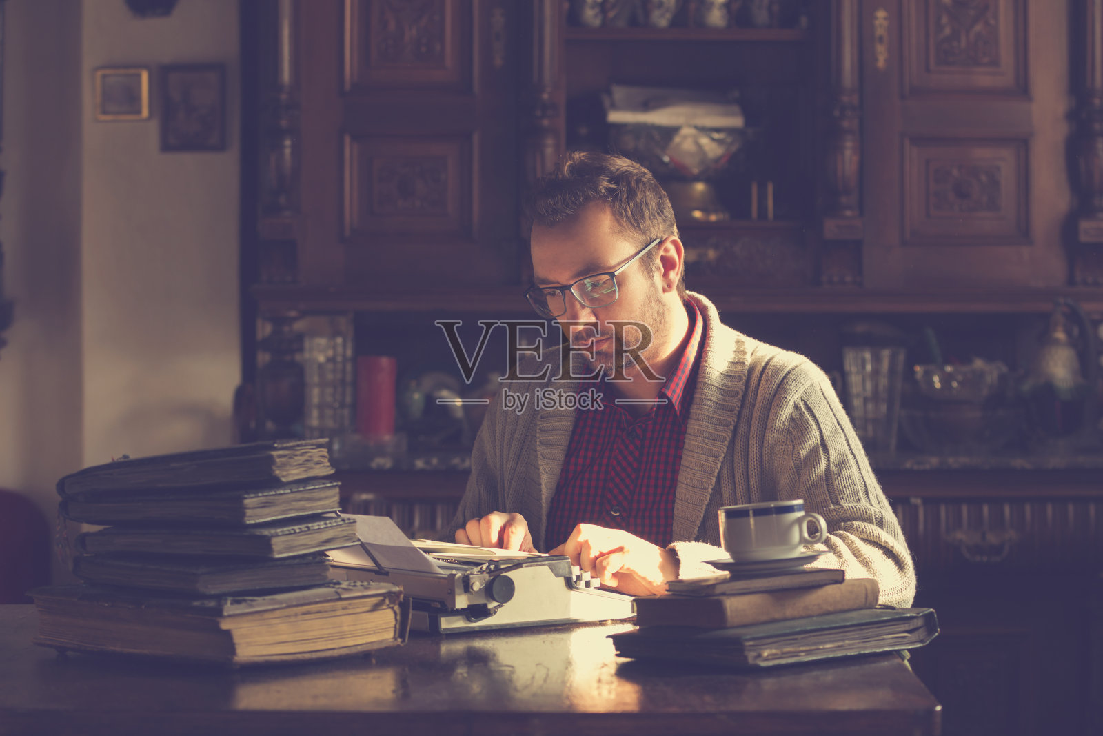 年轻人在旧打字机上写字。照片摄影图片