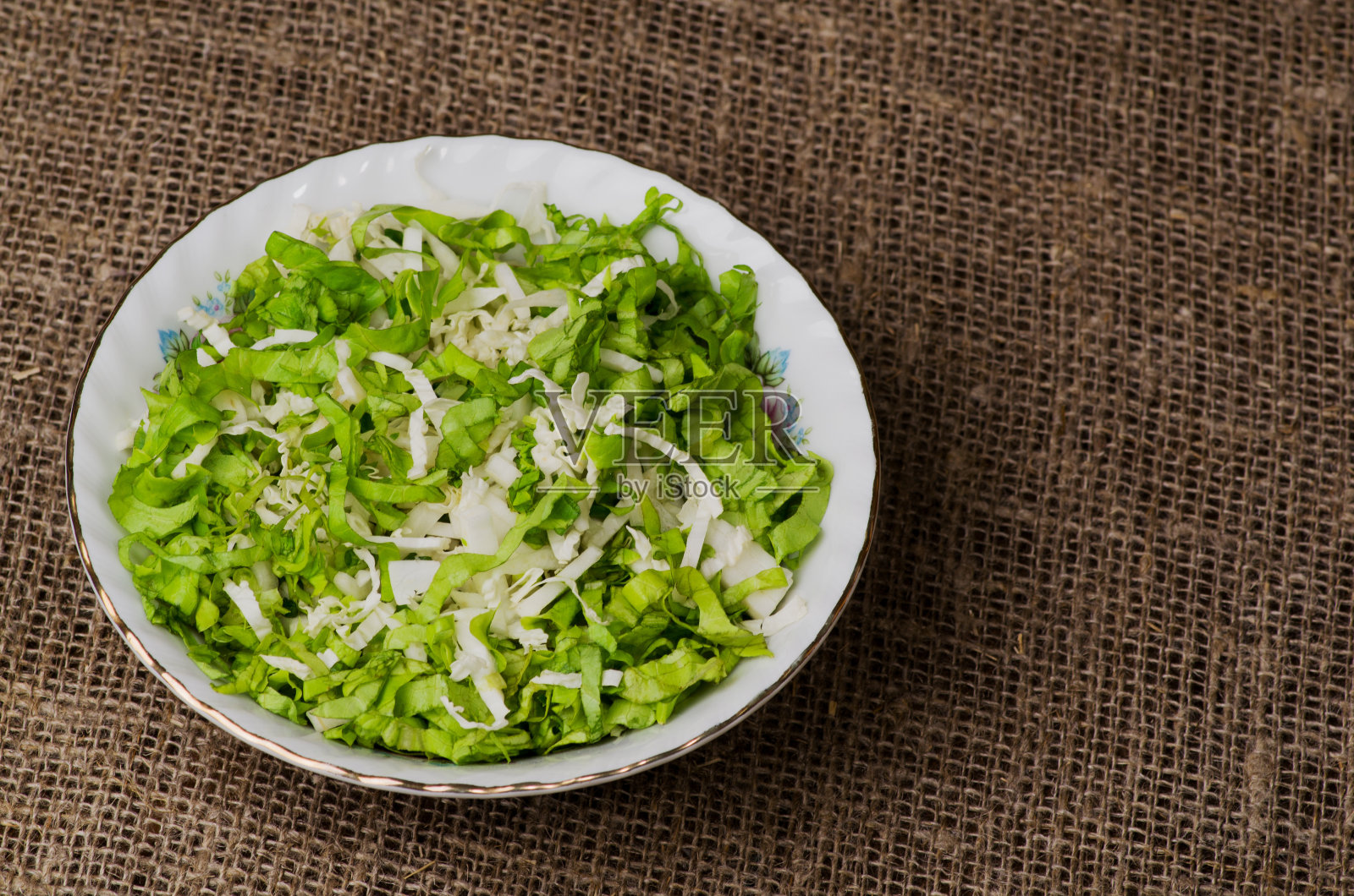 蔬菜沙拉放在木桌上的一个盘子里。照片摄影图片