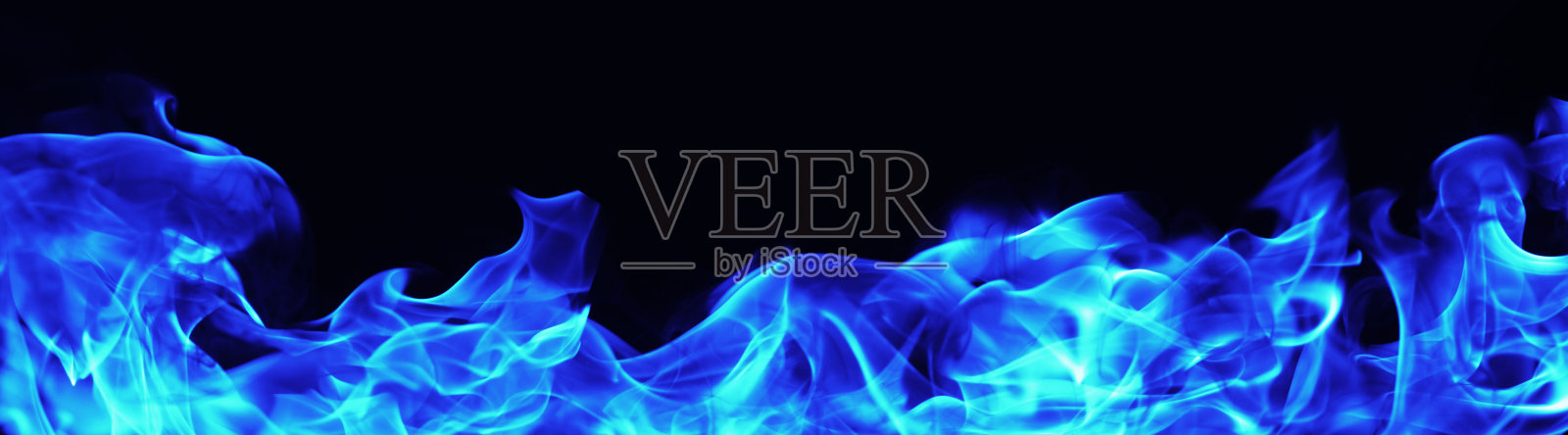 在黑色的背景上燃烧着蓝色的火焰照片摄影图片