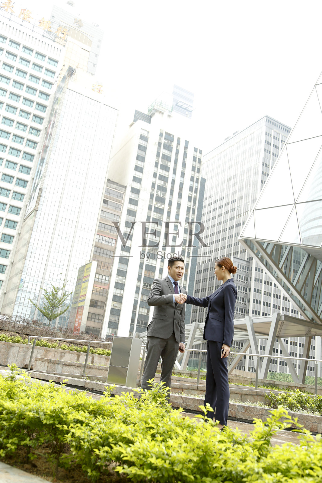 亚洲商人和职业女性在办公大楼外交谈照片摄影图片