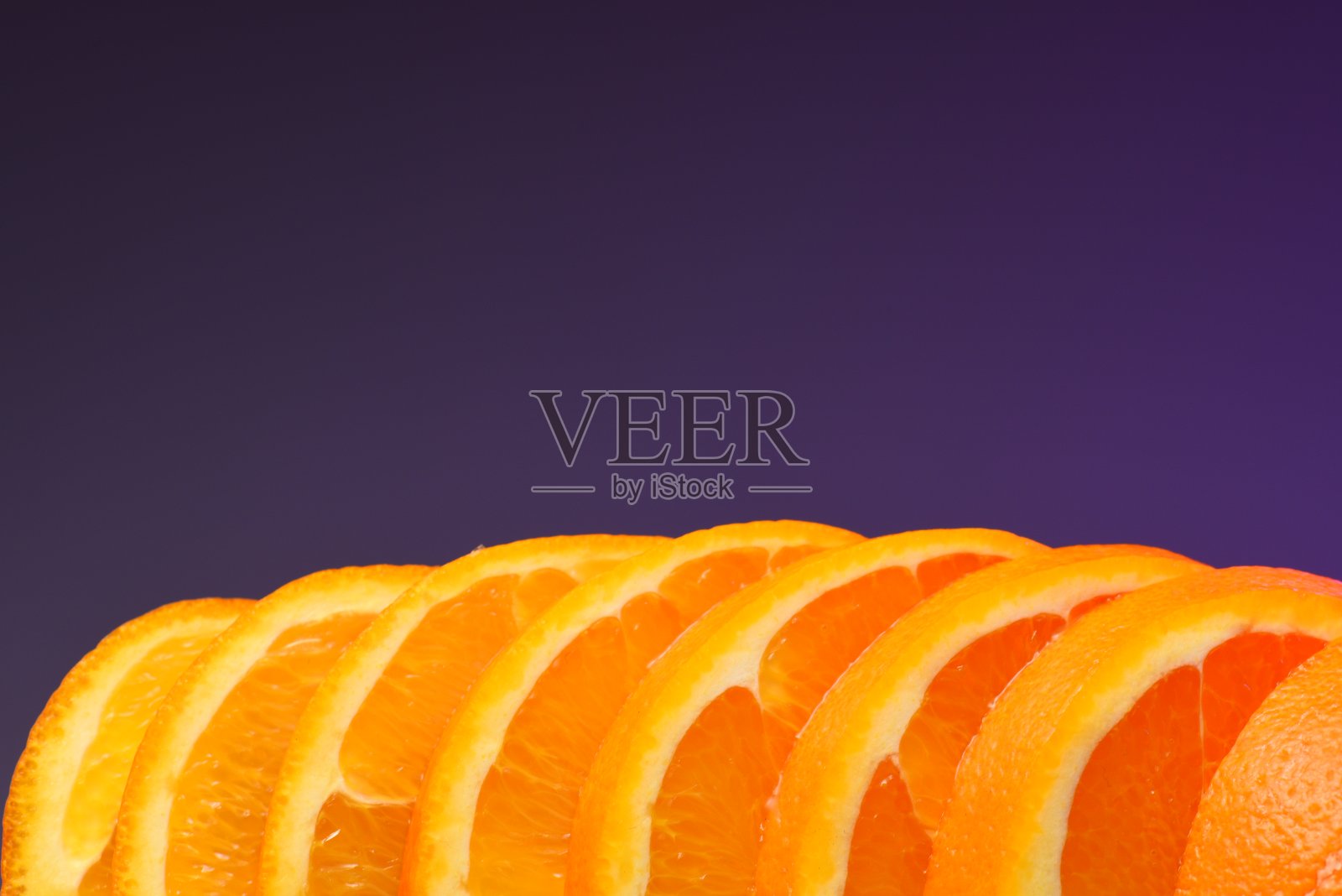 橘片，紫色背景。照片摄影图片