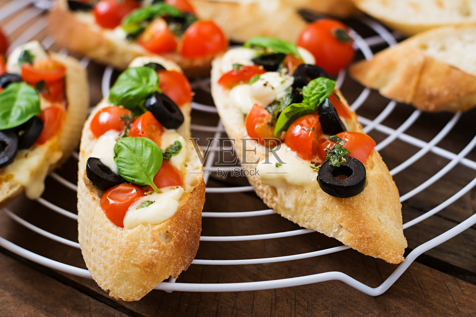 意式烤面包配番茄、马苏里拉奶酪、橄榄和罗勒香蒜沙司照片摄影图片