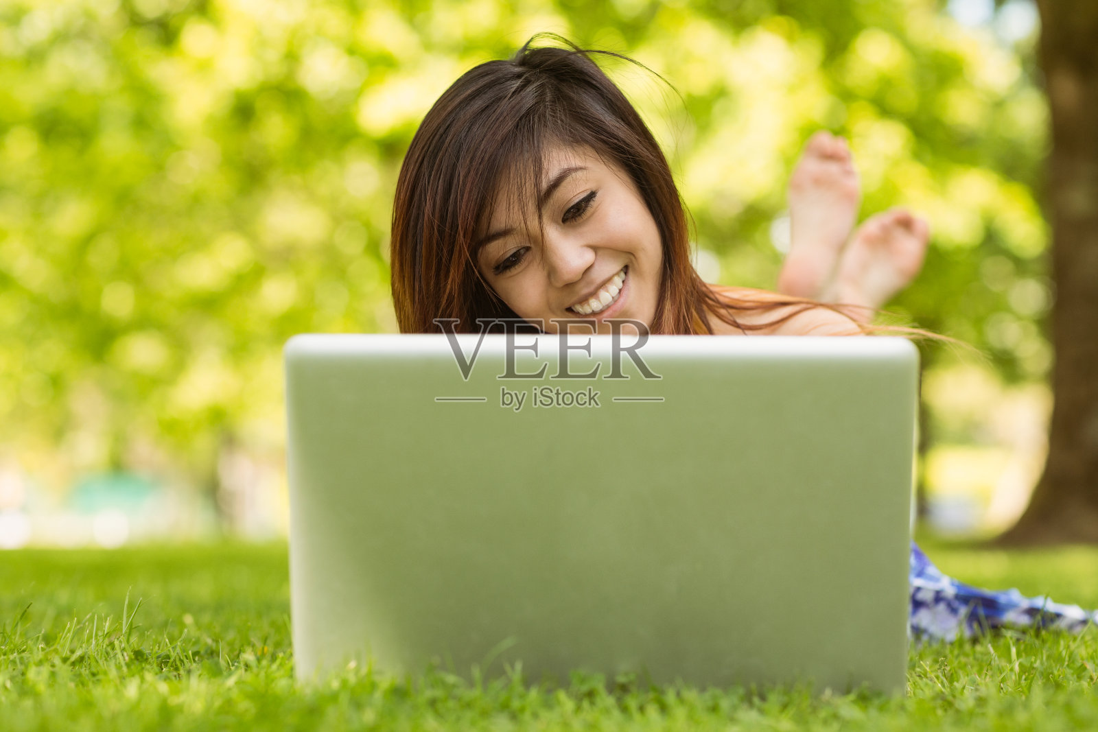 轻松的女人在公园使用笔记本电脑照片摄影图片