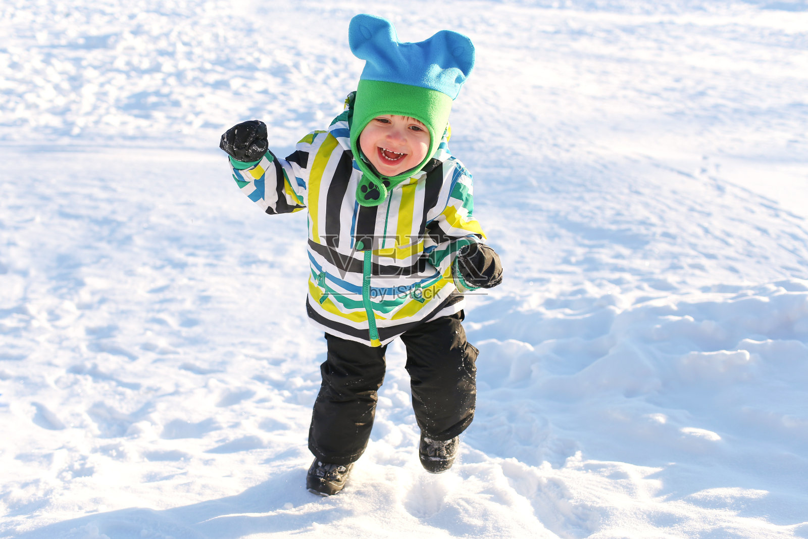 微笑快乐的幼童在冬天的户外跑步照片摄影图片