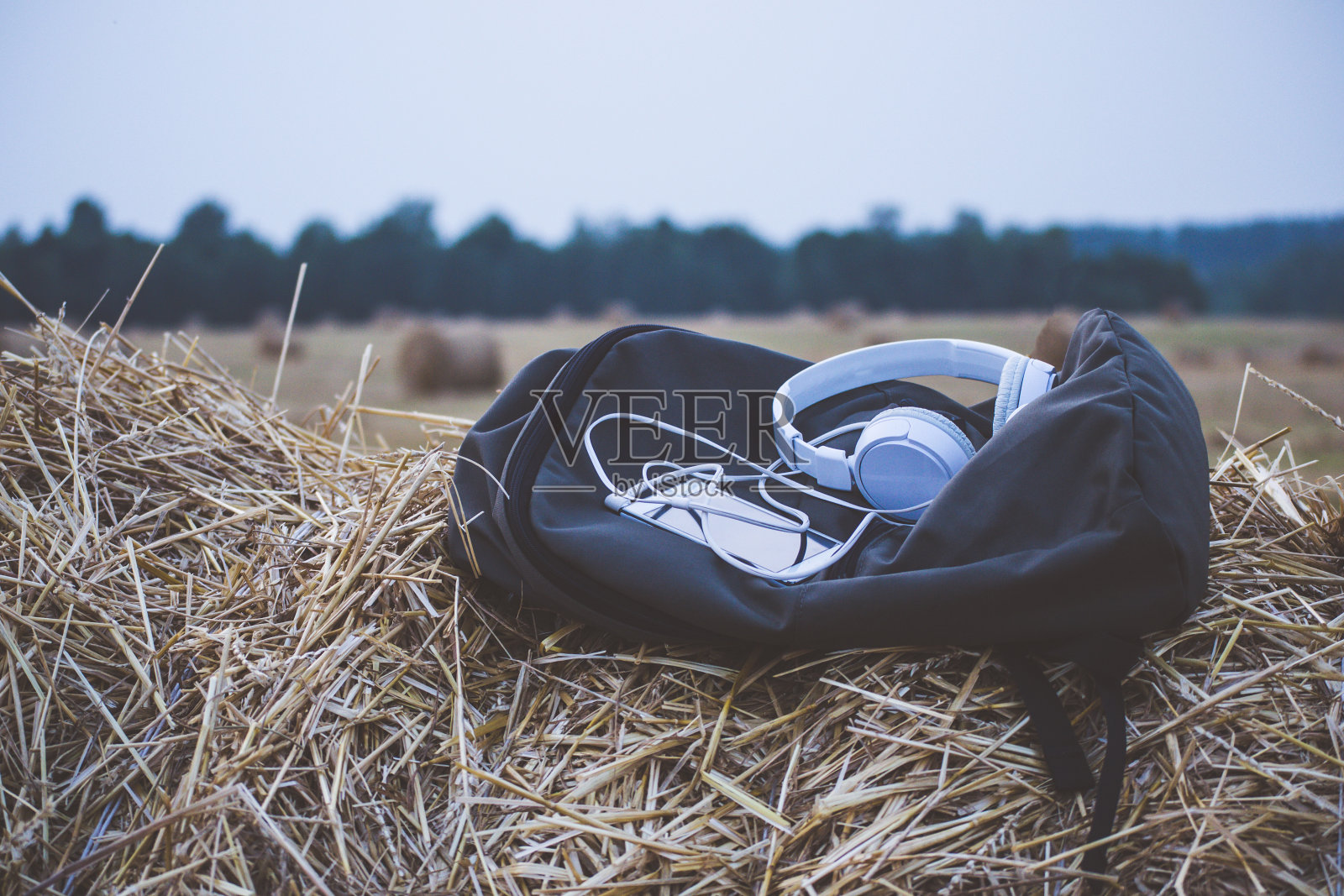 背包和小玩意放在草堆上照片摄影图片