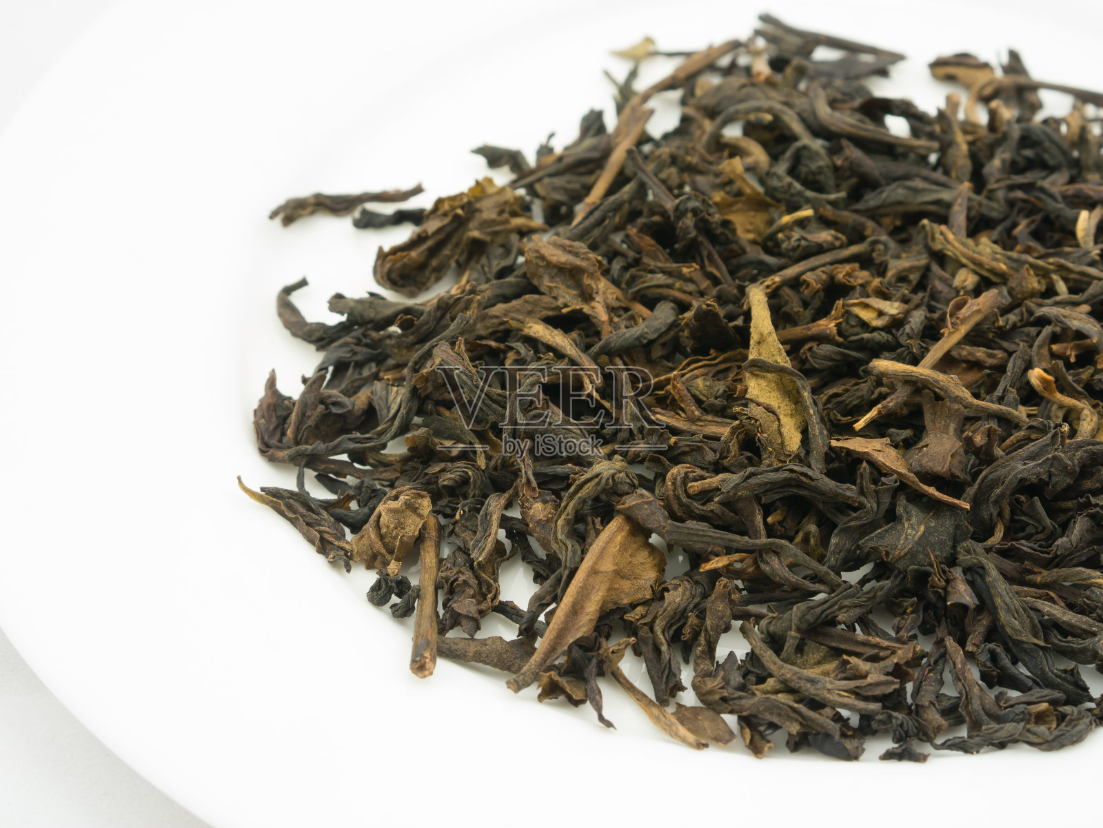 将干燥的伯爵茶叶子放在白色的盘子上照片摄影图片