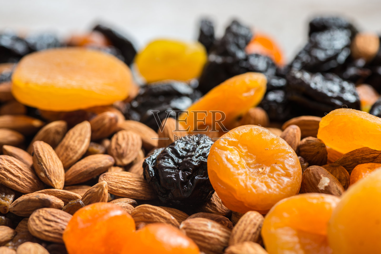 西梅，杏干，干桔子和杏仁在一个轻木制的背景照片摄影图片