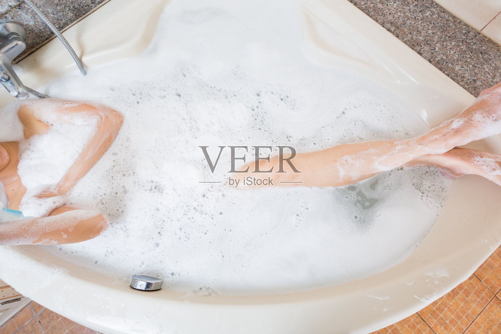 年轻漂亮的女孩在浴缸里洗澡。照片摄影图片