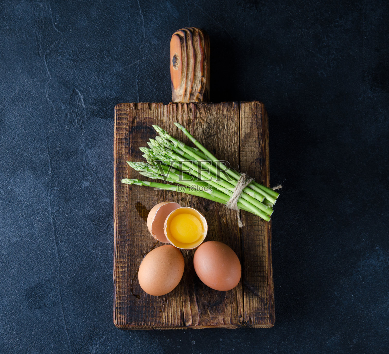 新鲜的绿芦笋和鸡蛋放在石头桌上照片摄影图片