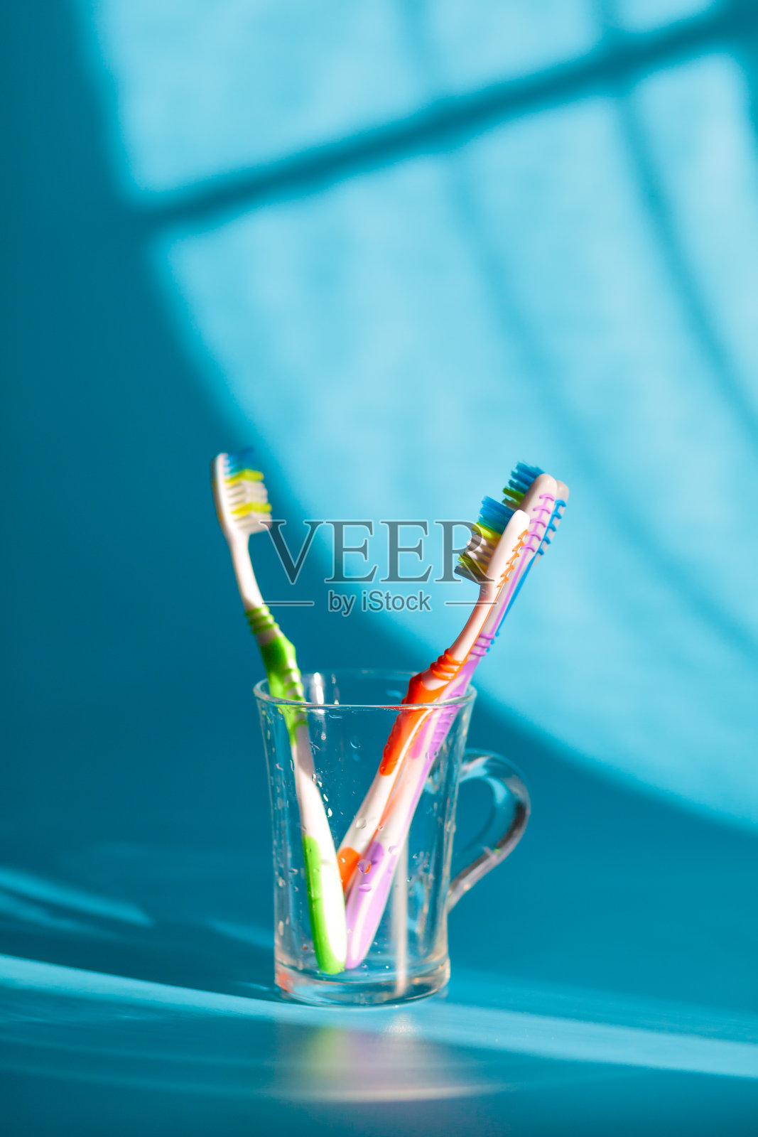 玻璃上放着五颜六色的牙刷照片摄影图片