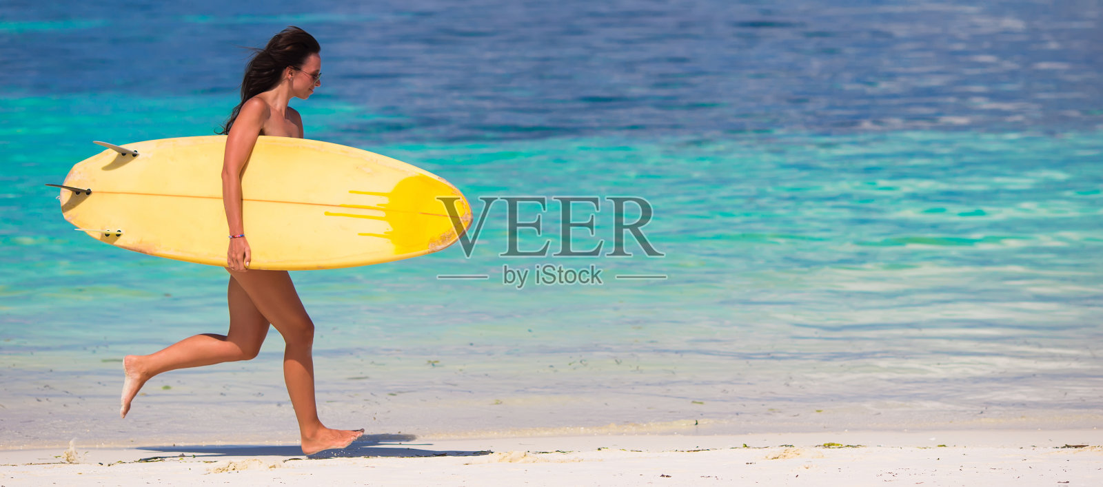 快乐的年轻冲浪女在海滩上玩冲浪板照片摄影图片