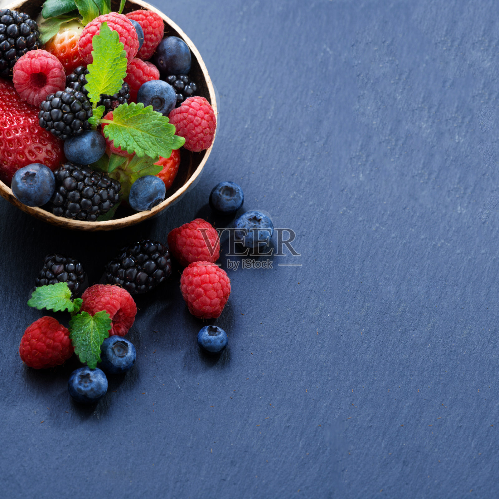 各种新鲜的花园浆果在黑色的背景照片摄影图片