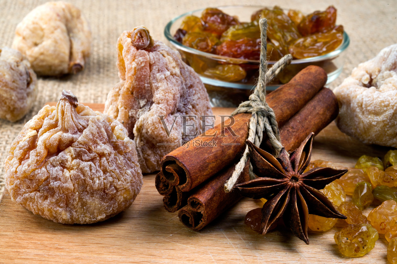 木盘上放无花果、肉桂、大茴香和葡萄干，有选择地放照片摄影图片