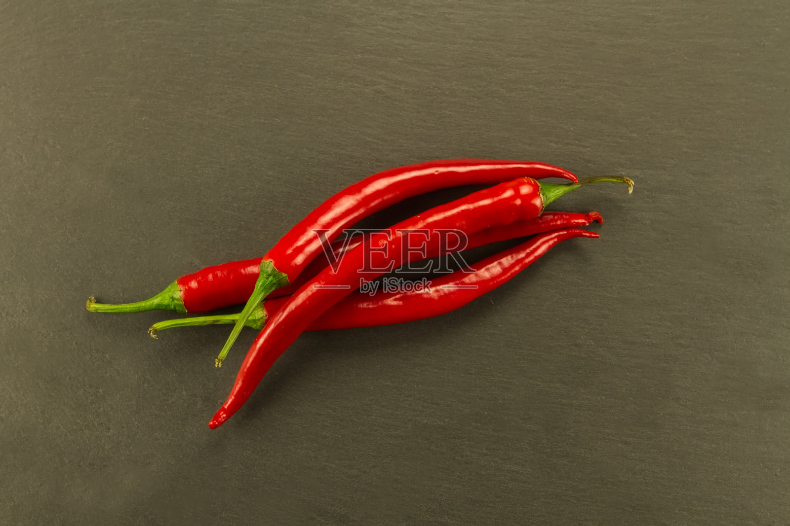 红辣椒在复古的黑色桌子上。照片摄影图片