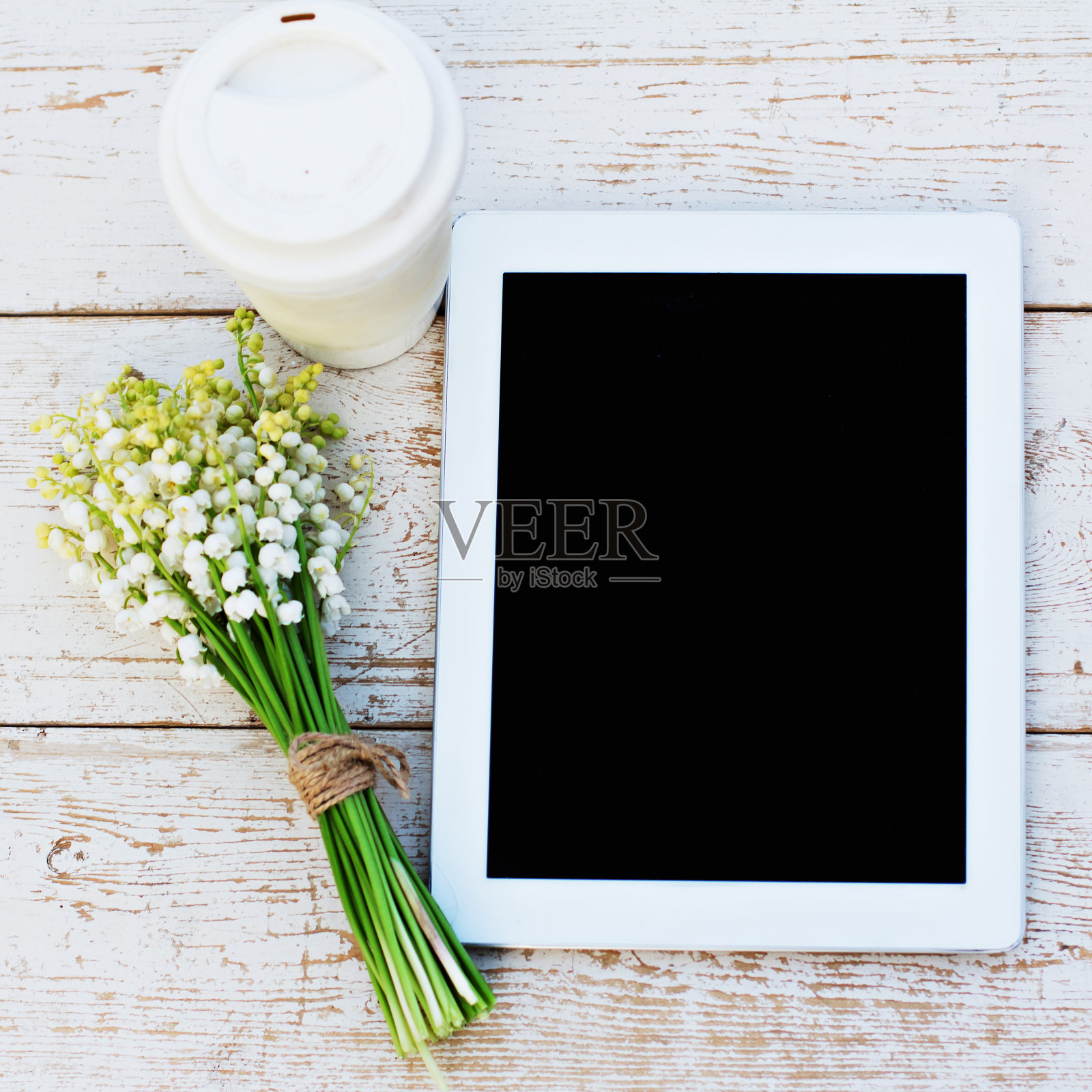 平板电脑，一杯咖啡和铃兰照片摄影图片