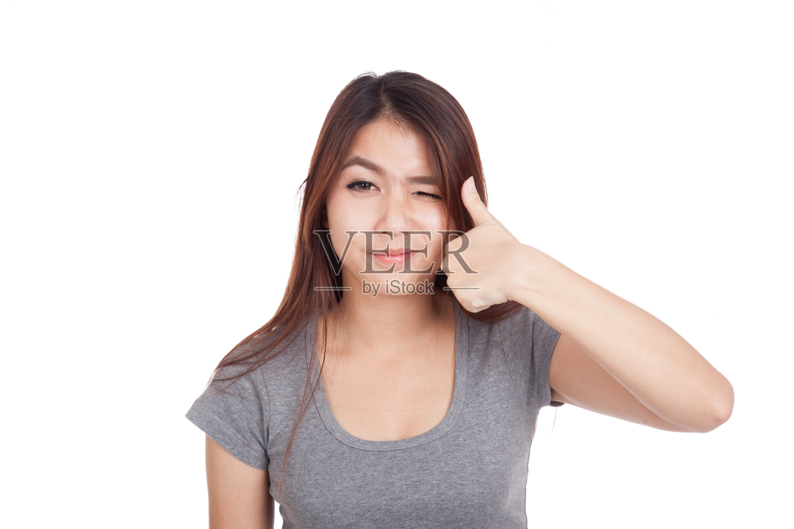 年轻的亚洲妇女眨着眼睛，竖起大拇指照片摄影图片