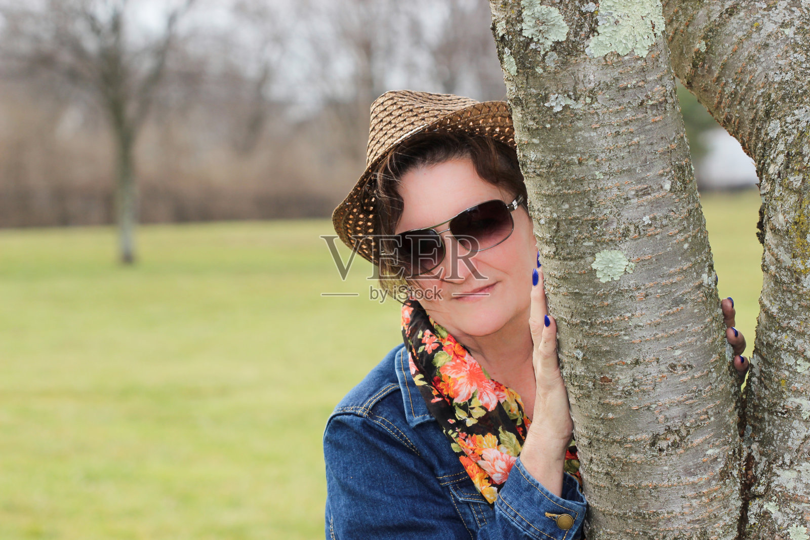 一名女子把手放在树上准备拍照照片摄影图片