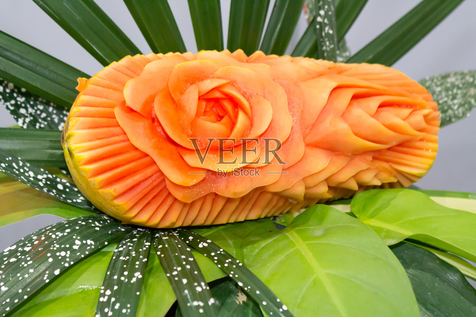 木瓜果雕成玫瑰的形状。照片摄影图片